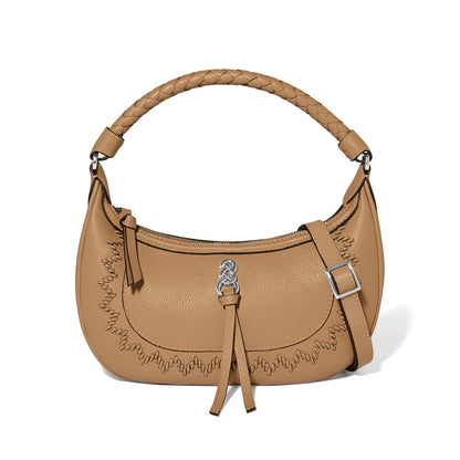 Brighton tan leather handbag with braided top handle, whipstitch trim, knotted charm, and adjustable strap on a white background