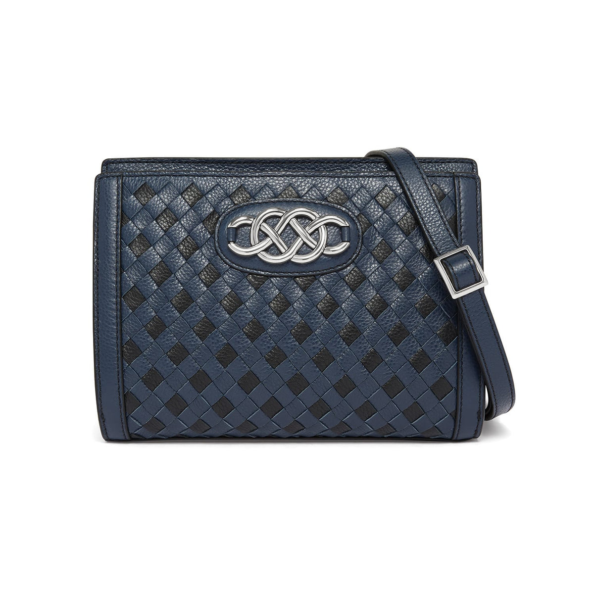 Brighton crossbody handbag with navy and black woven leather, silver-tone knot medallion, and adjustable strap on a white background