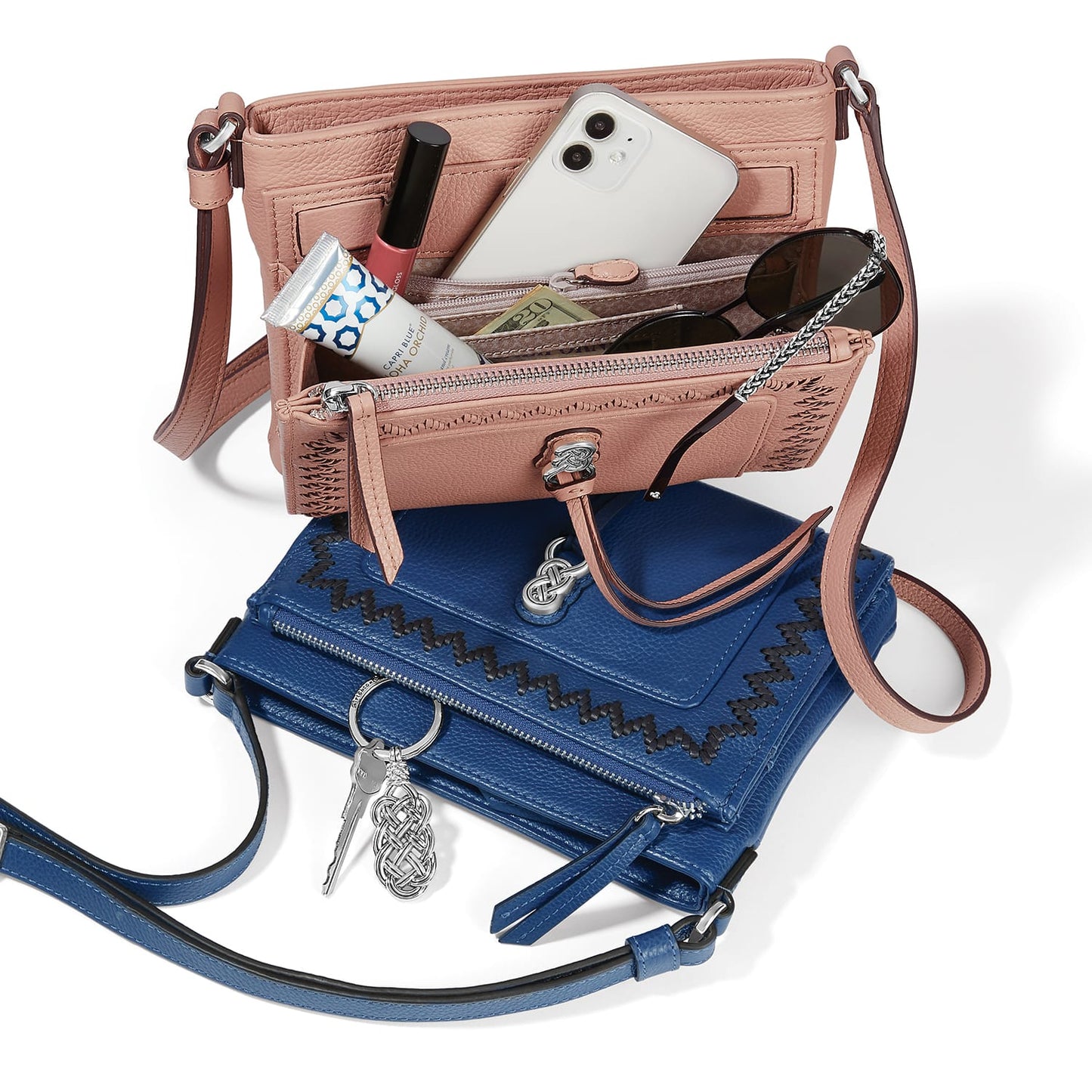 Brighton handbags styled with phone, sunglasses, lip gloss, and keys on a white background