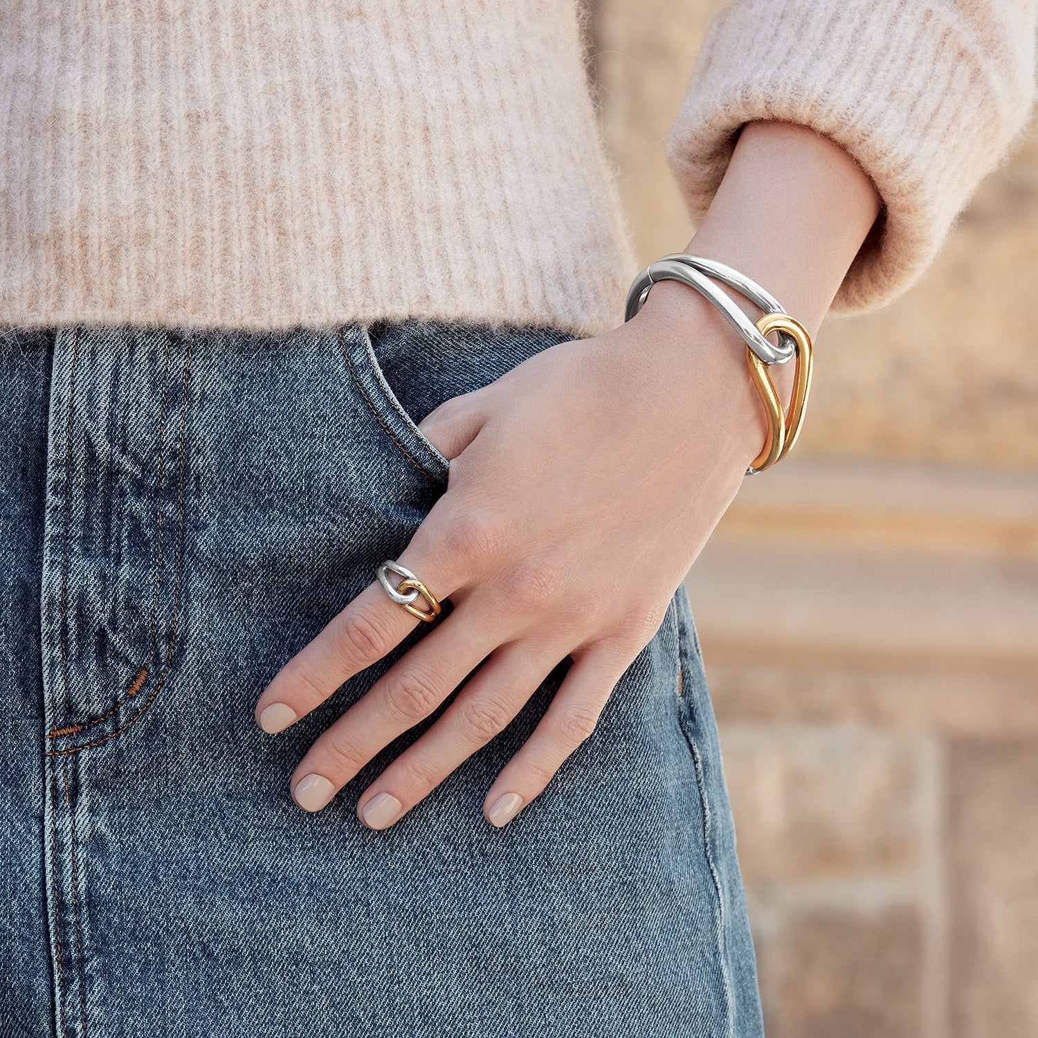 Model wearing a Brighton two-tone silver and gold interlocking bangle bracelet paired with a matching two-tone ring