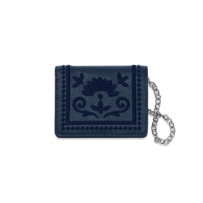Brighton navy leather wallet with embroidered floral medallion design and silver-tone chain wristlet on a white background