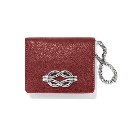 Brighton red pebbled leather wallet with silver-tone knot emblem and silver chain wristlet on a white background