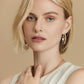 Model wearing Brighton two-tone hoop earrings with enamel detail and coordinating Brighton accessories