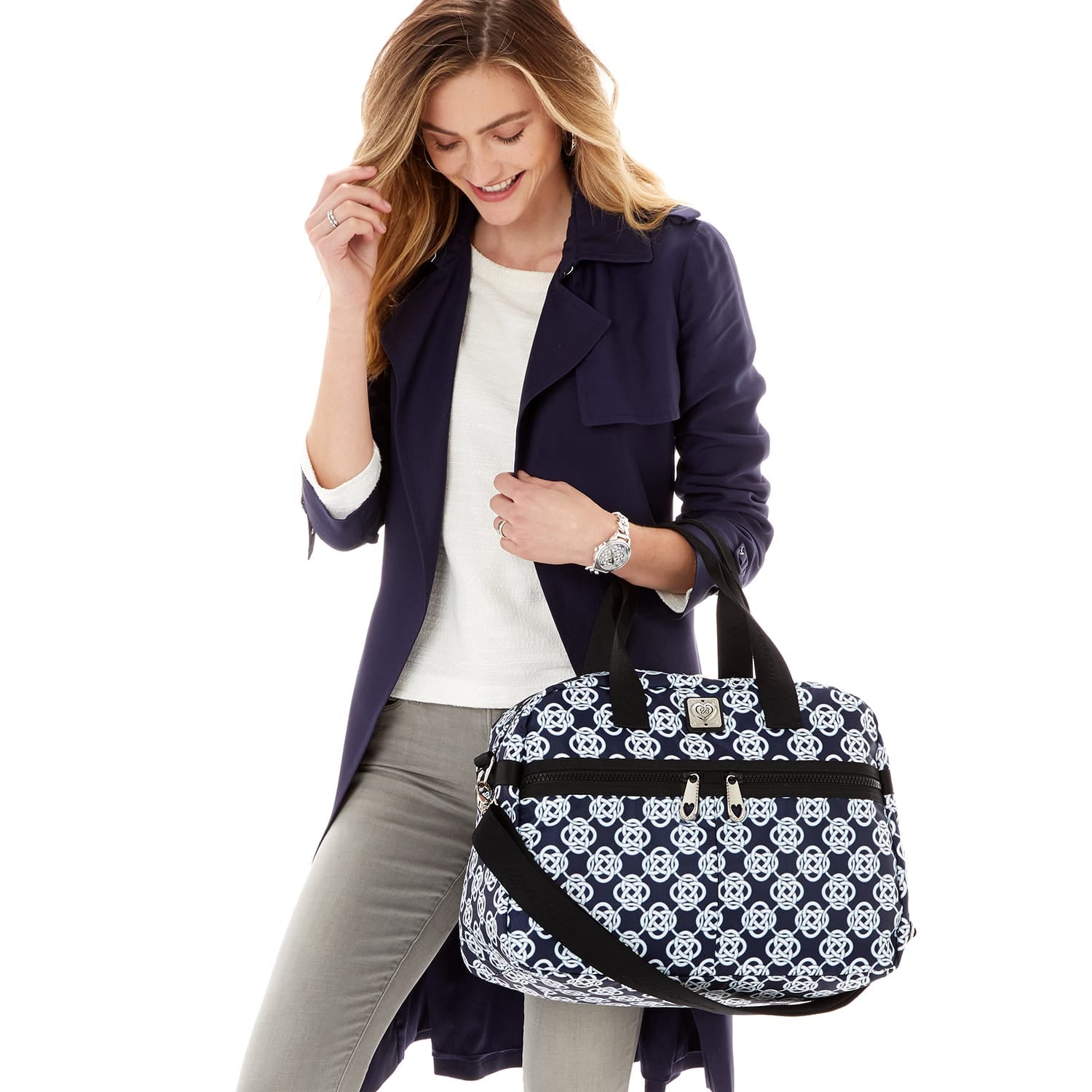 Model with a Brighton handbag in navy and white geometric print with black handles and zipper closure