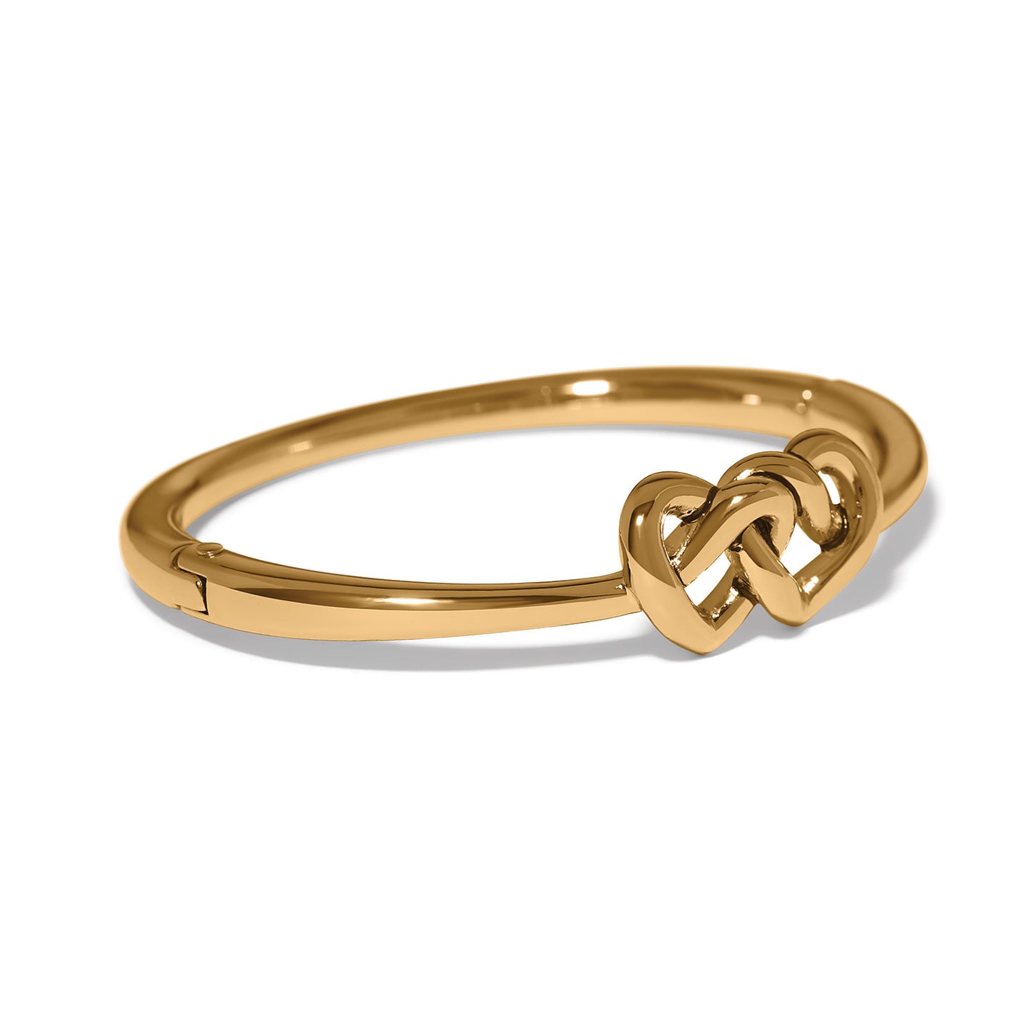 Brighton gold-plated hinged bangle bracelet with interlocking heart knot centerpiece on a white background