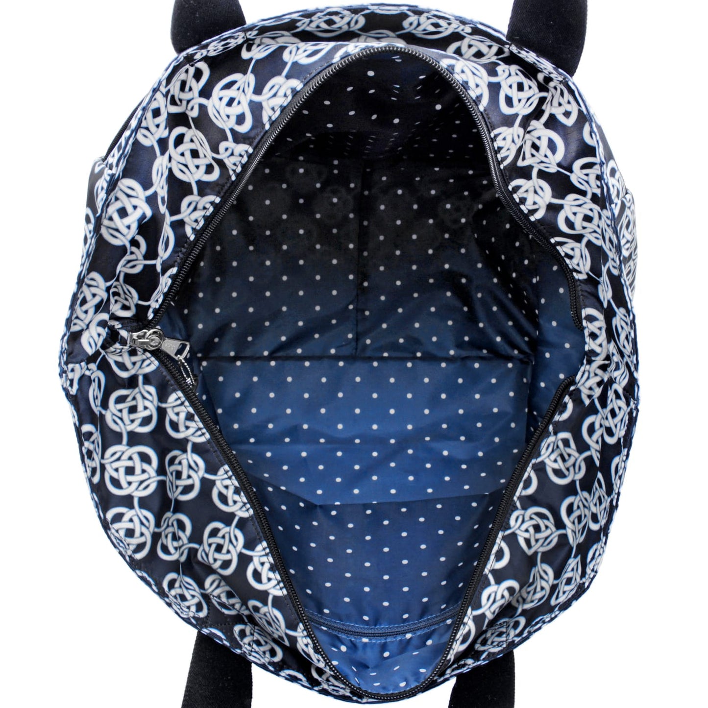 Close-up of Brighton handbag interior view showing blue polka dot lining and black Celtic knot printed exterior