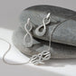 Brighton silver-plated infinity necklace and matching drop earrings with crystal accents styled with smooth gray stones