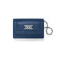 Brighton navy blue pebbled leather wallet with silver-tone interlocking knot emblem, woven detail, and chain wristlet on a white background