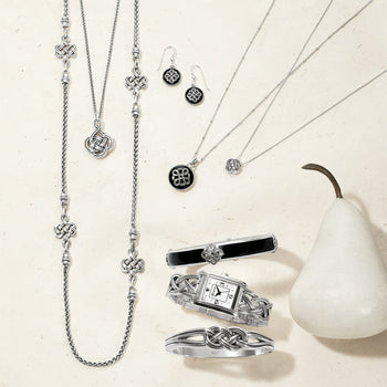 Brighton silver-plated jewelry collection styled with a white pear and Celtic knot motifs on a neutral background