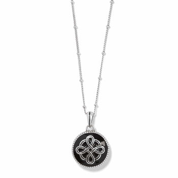 Brighton pendant necklace with black enamel disc, silver-plated Celtic knot design, and beaded chain on a white background