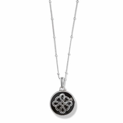 Brighton pendant necklace with black enamel disc, silver-plated Celtic knot design, and beaded chain on a white background