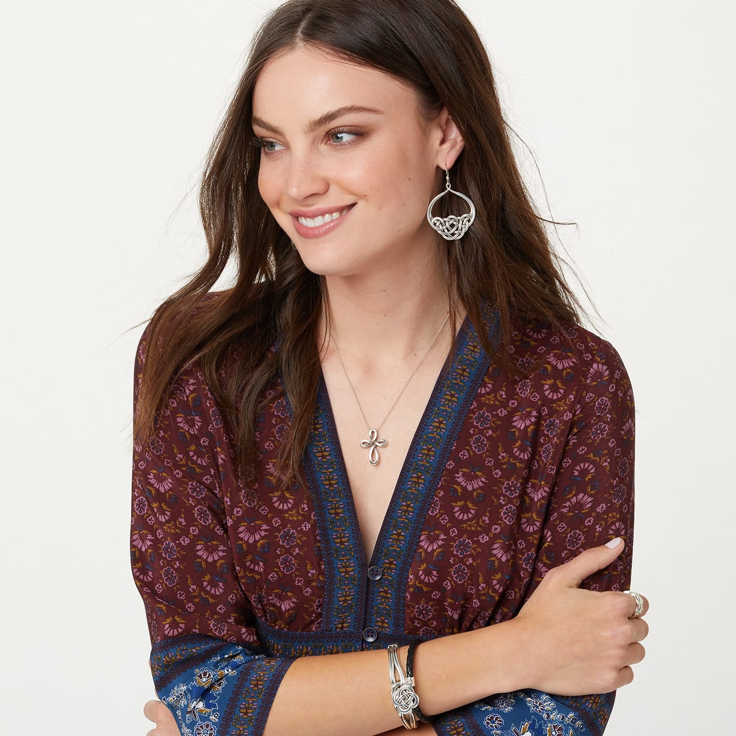 Model wearing a Brighton silver-plated Celtic knot cross pendant necklace with coordinating Brighton accessories