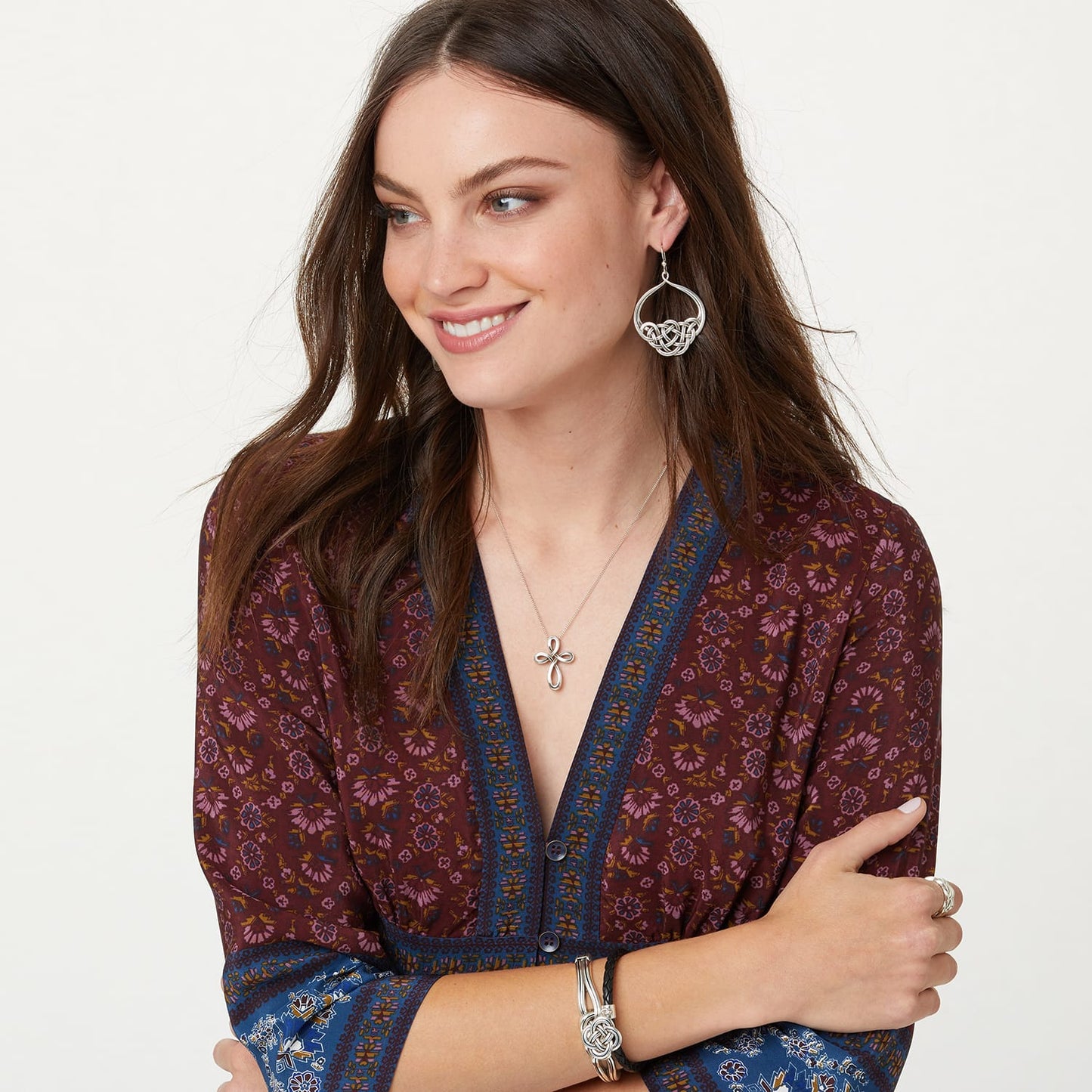 Model wearing a Brighton silver-plated Celtic knot cross pendant necklace with coordinating Brighton accessories