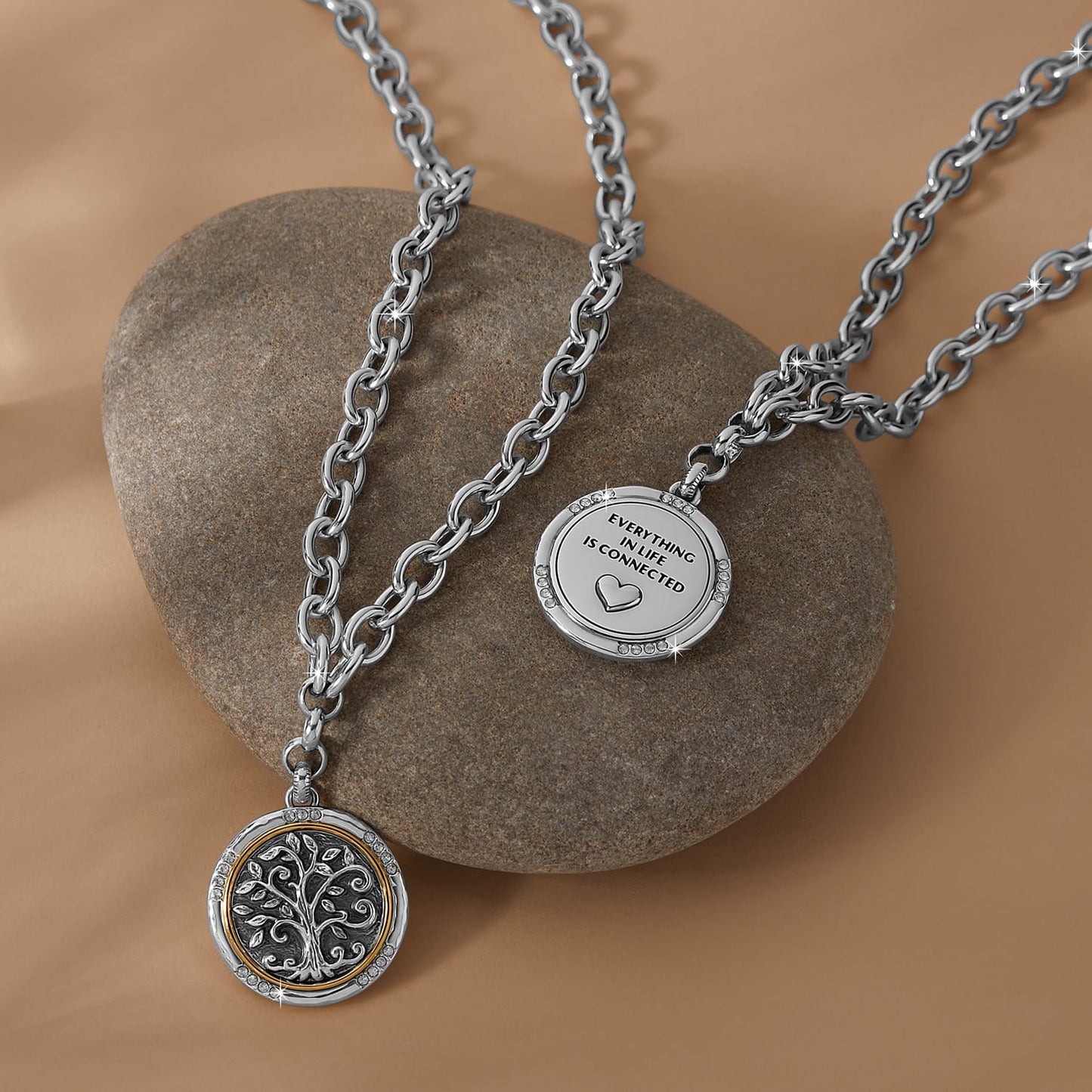 Brighton two-tone pendant necklaces styled with a smooth stone, featuring tree of life and engraved heart medallions