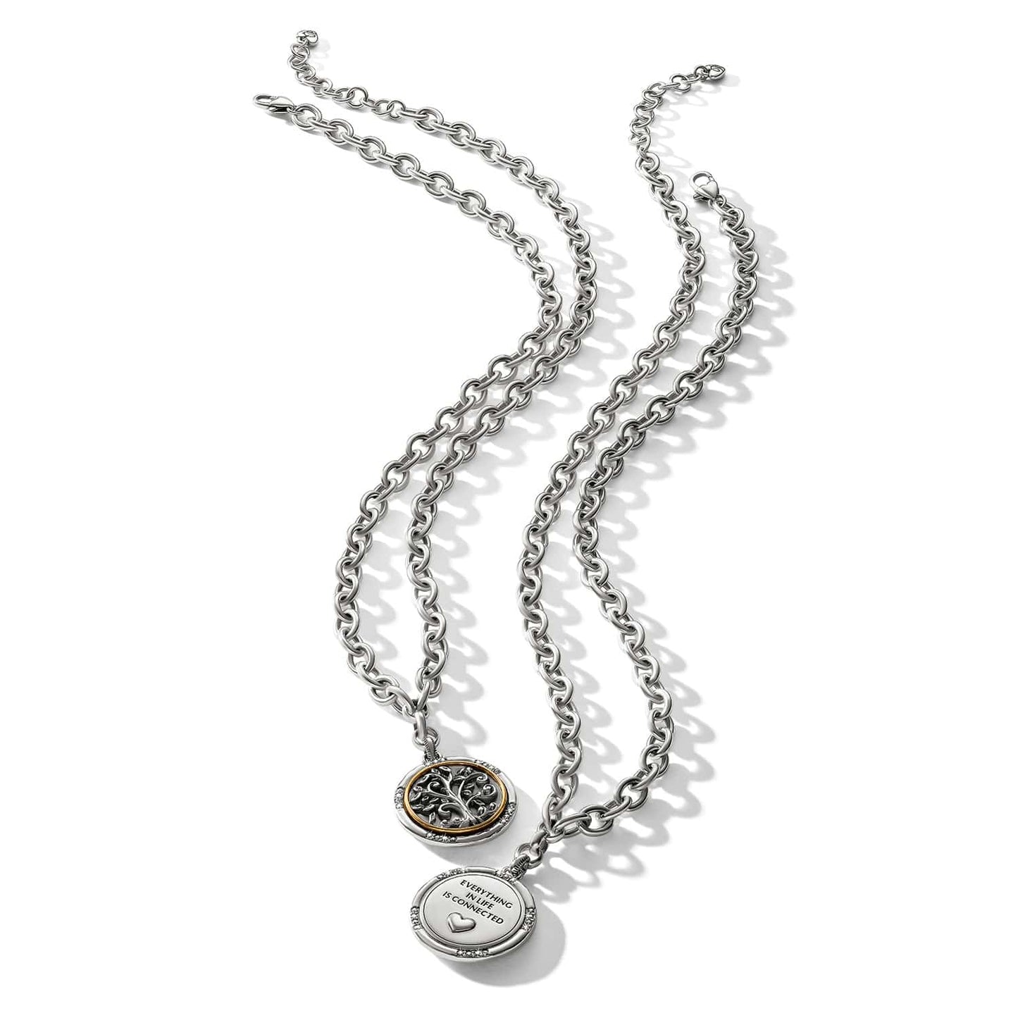 Brighton two-tone pendant necklaces with tree of life medallion and engraved heart charm on a white background