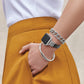 Model wearing a Brighton watch with black leather band and silver-plated accents, styled with coordinating Brighton bracelets