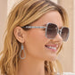 Model wearing Brighton square sunglasses with silver-tone braided temple detail paired with silver Celtic knot drop earrings