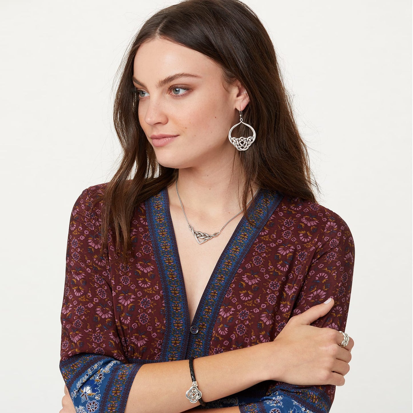 Model wearing Brighton silver-plated Celtic knot drop earrings paired with a matching interwoven heart pendant necklace