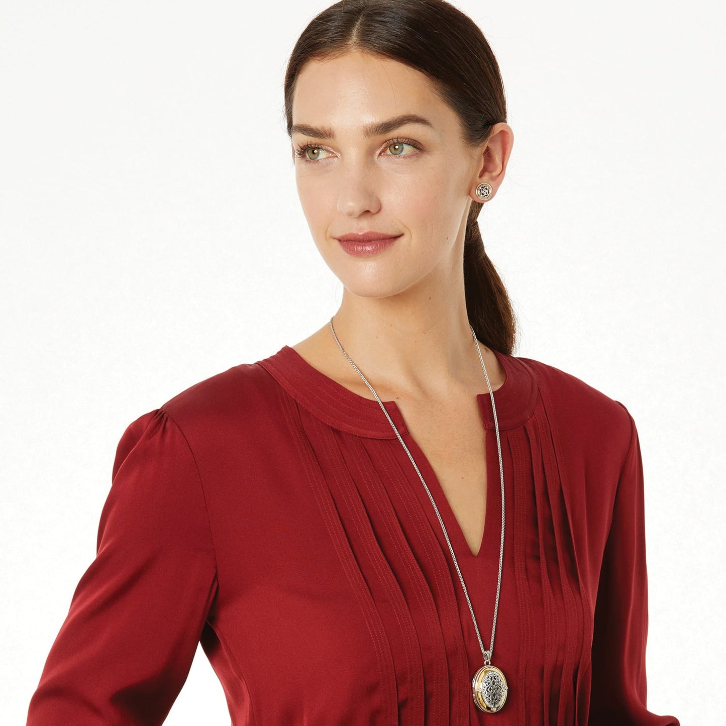 Model wearing a Brighton two-tone oval pendant necklace with ornate filigree design paired with matching stud earrings