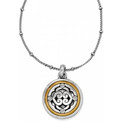 Brighton pendant necklace with silver-plated and gold-plated round medallion, scroll motif, and crystal accents on a white background