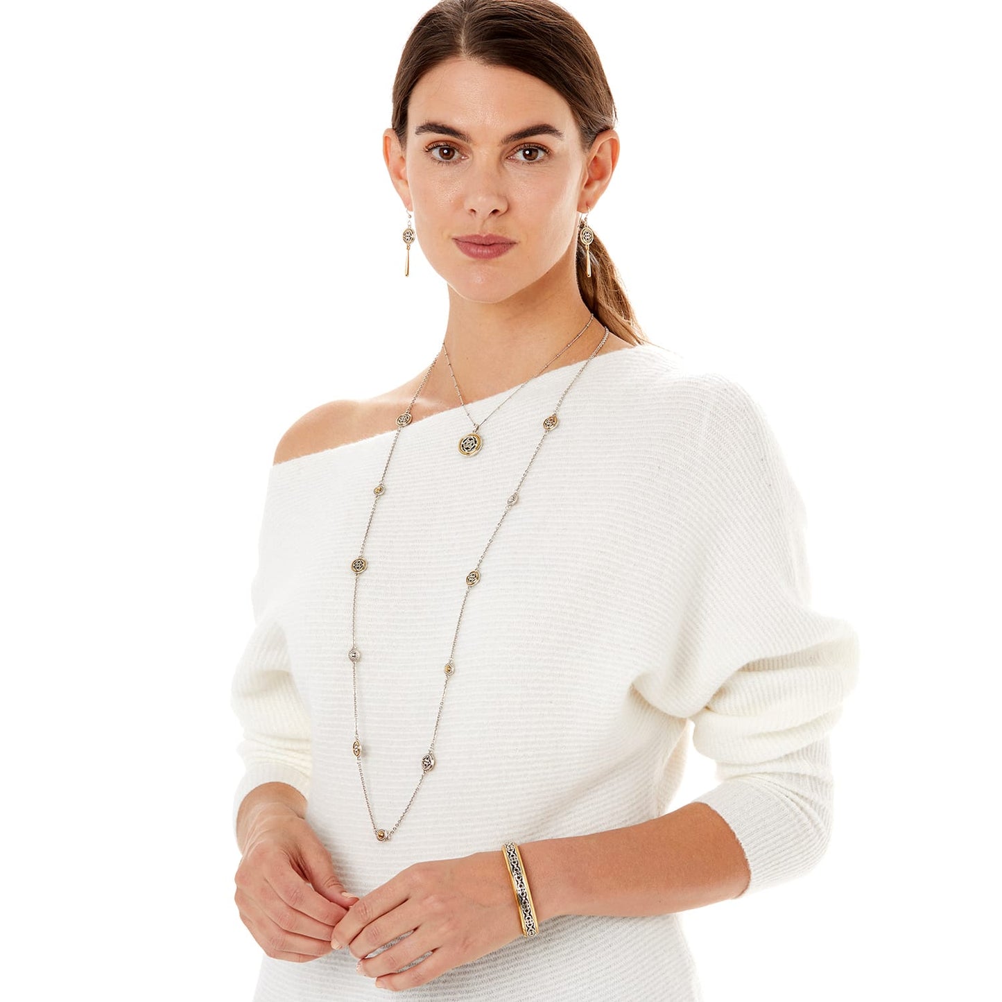 Model wearing a Brighton long silver-plated station necklace with gold-plated medallion accents and coordinating Brighton accessories