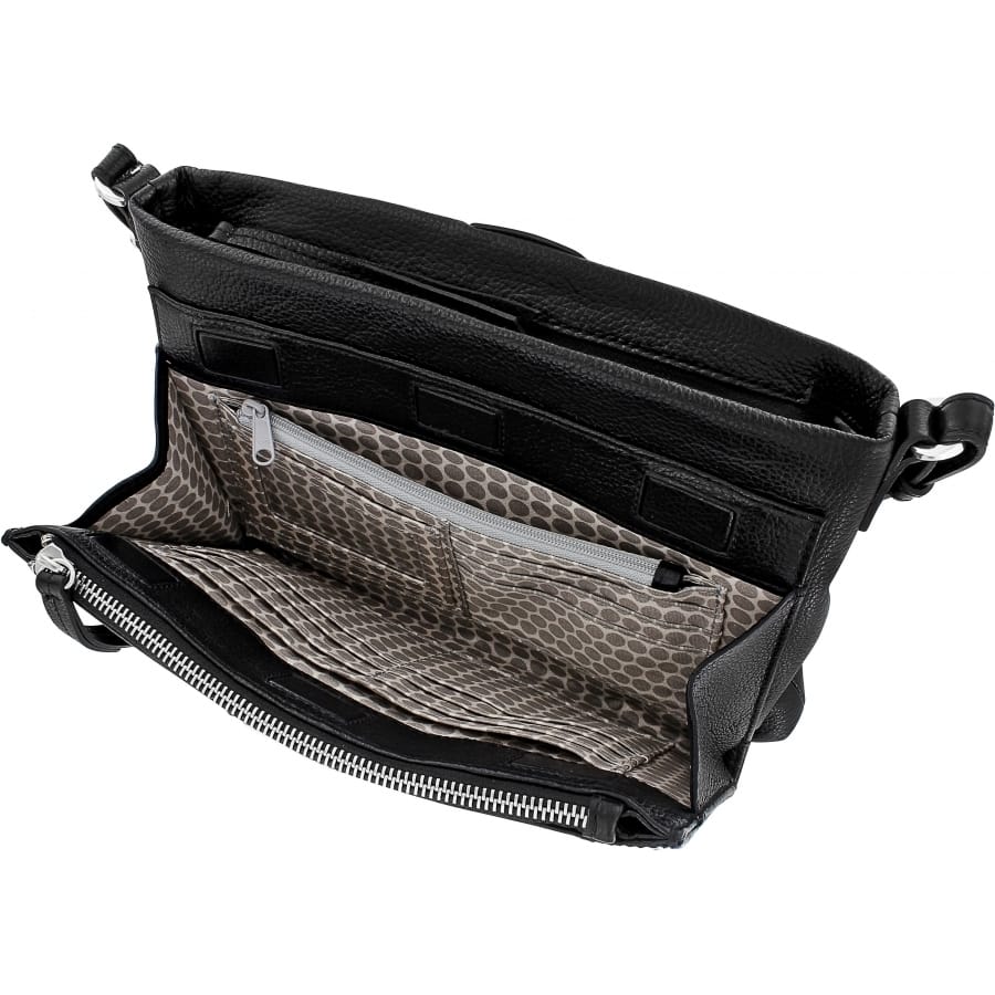 Brighton black leather handbag shown open with polka dot interior lining and zippered pocket on a white background