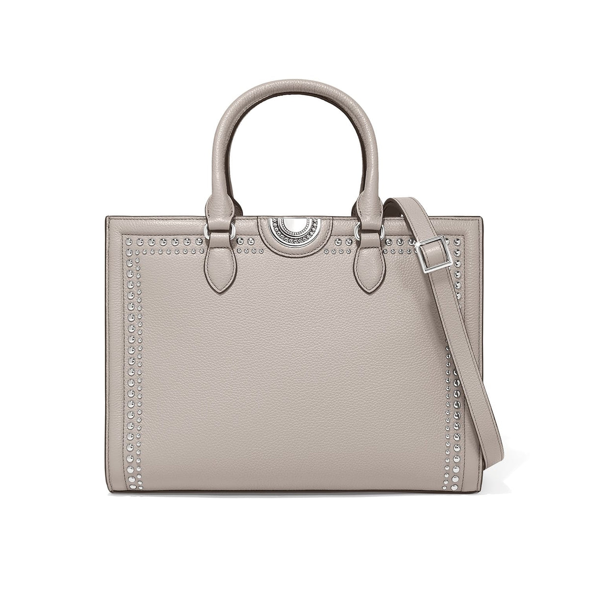 Brighton taupe leather handbag with silver-tone stud trim, medallion accent, dual handles, and adjustable shoulder strap on a white background