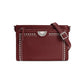 Brighton crossbody handbag in burgundy leather with silver-tone studs, medallion accent, and adjustable strap on a white background