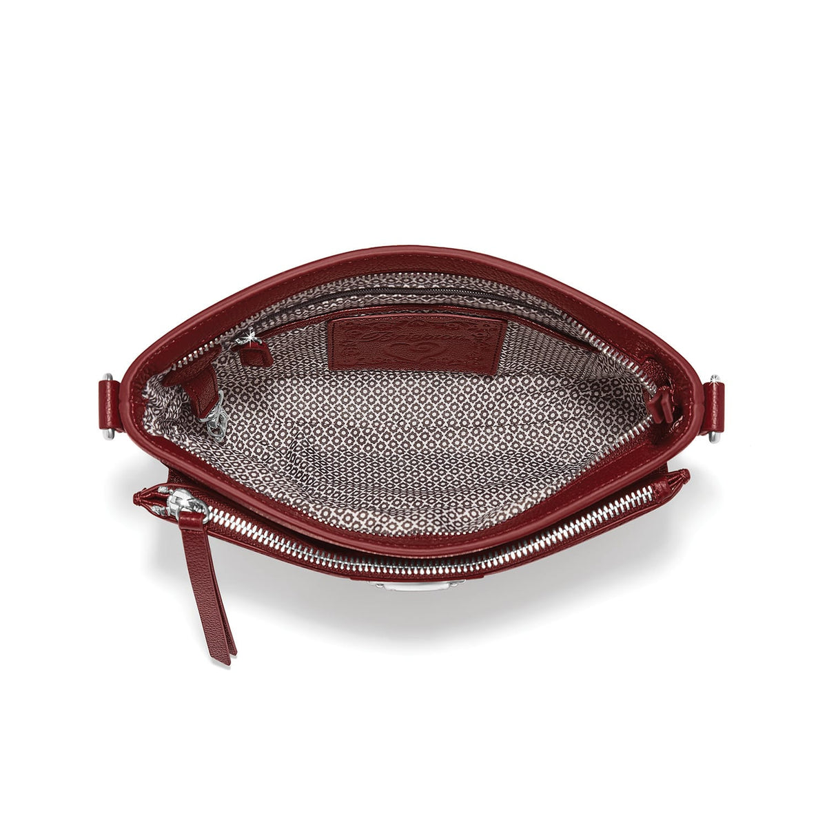 Brighton red leather handbag shown open with patterned fabric lining, interior pocket, and silver-tone zipper on a white background