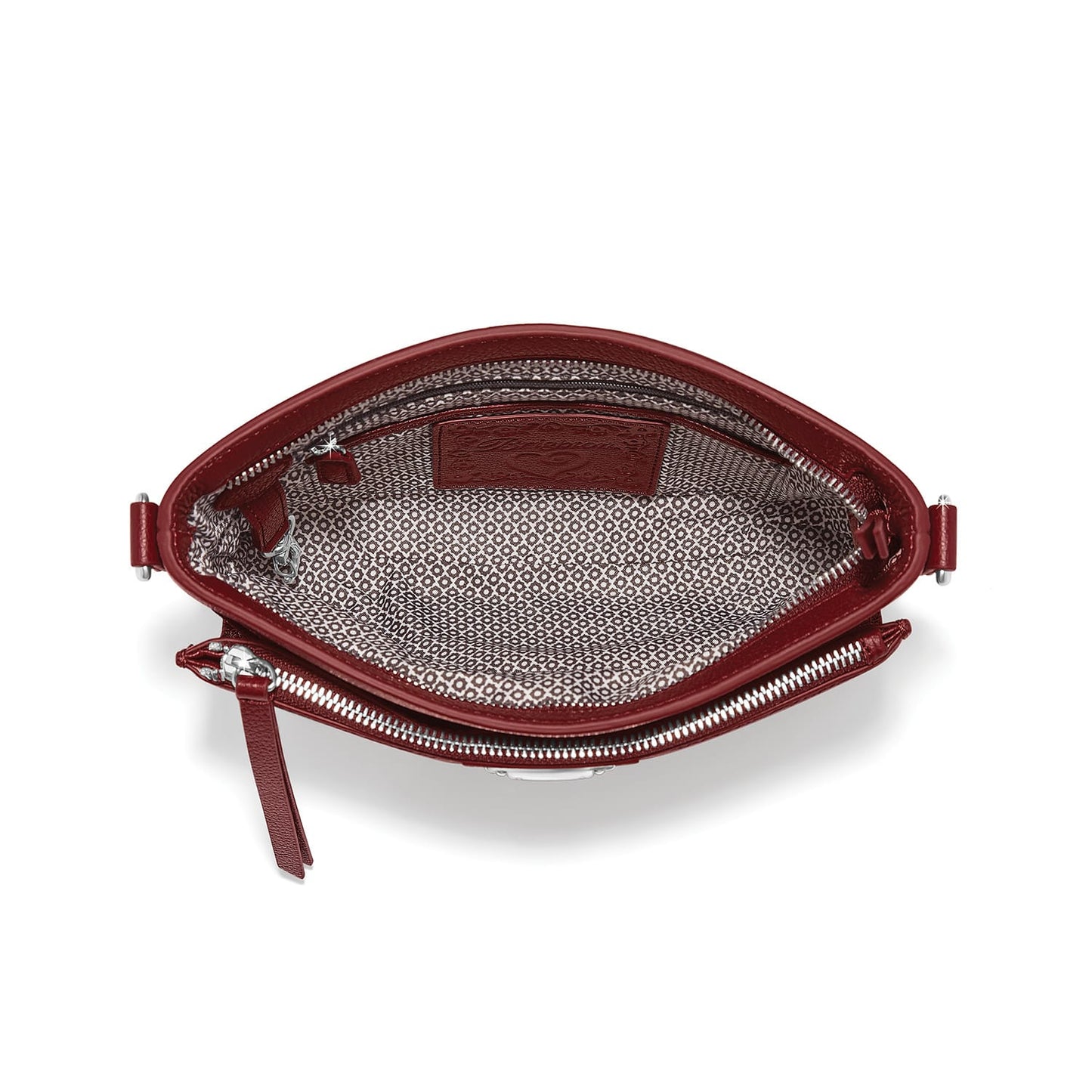 Brighton red leather handbag shown open with patterned fabric lining, interior pocket, and silver-tone zipper on a white background