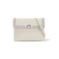 Brighton crossbody handbag in cream leather with studded flap, silver-tone turn-lock clasp, and adjustable strap on a white background