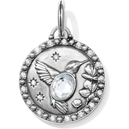 Brighton silver-plated charm pendant with hummingbird, flowers, stars, central crystal, and pave crystal border on a white background