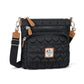 Brighton crossbody handbag in black heart-quilted fabric with tan leather trim and adjustable strap on a white background
