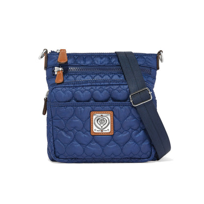 Brighton crossbody handbag in navy quilted heart pattern with leather trim and adjustable strap on a white background