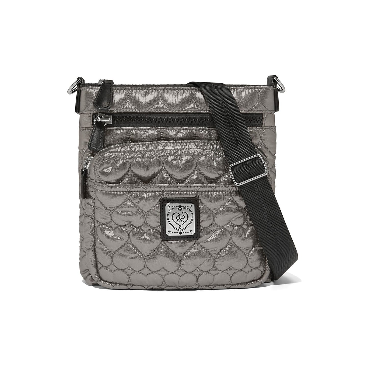 Brighton crossbody handbag in metallic pewter with quilted heart pattern, black adjustable strap, and logo patch on a white background