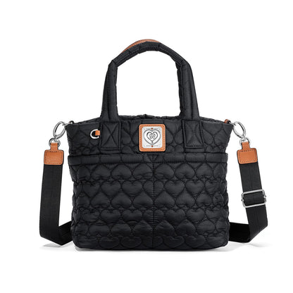 Brighton tote handbag in black quilted heart pattern with leather trim and adjustable crossbody strap on a white background