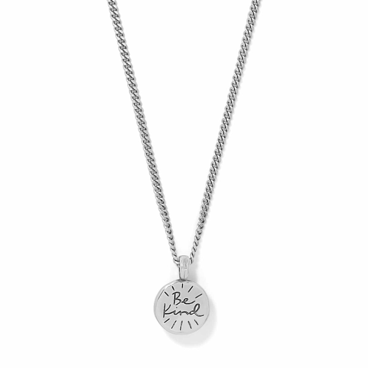 Brighton pendant necklace with round silver-tone charm engraved with Be Kind script on a white background