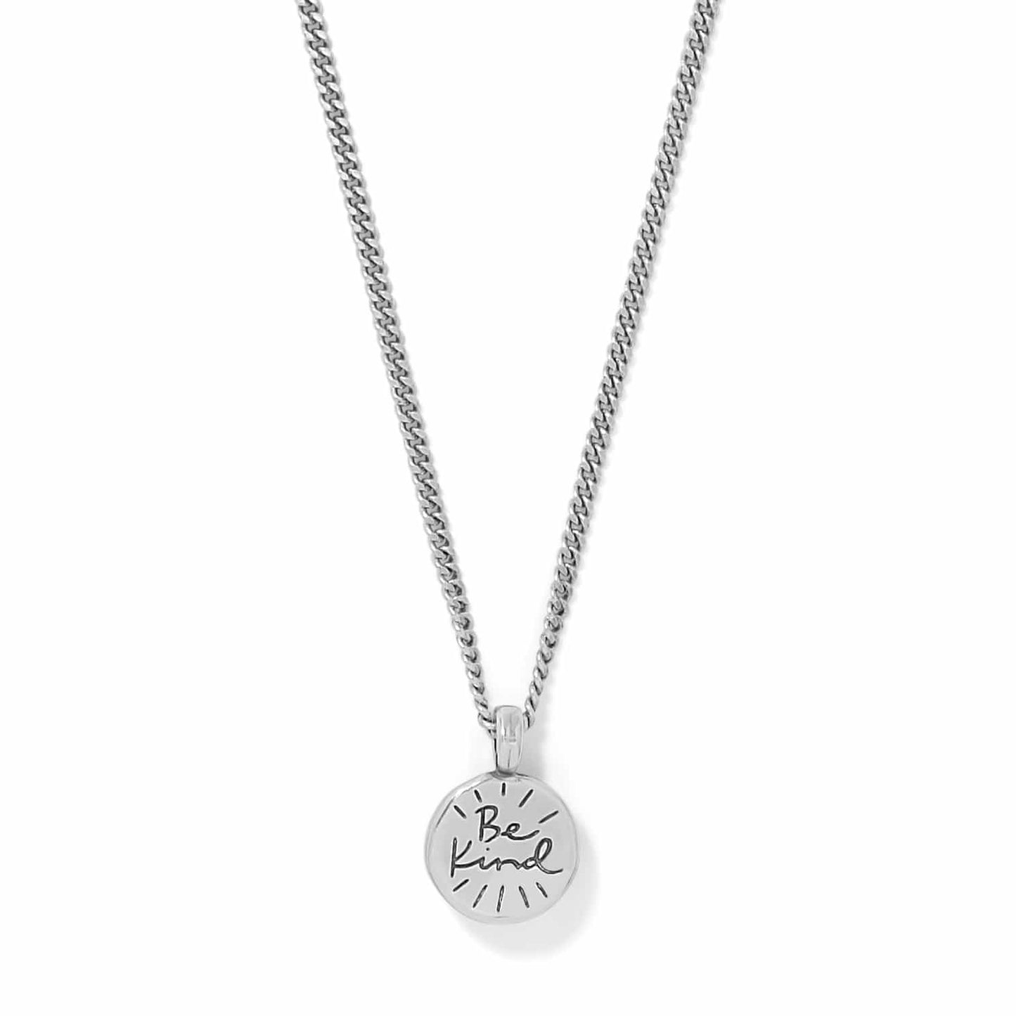 Brighton pendant necklace with round silver-tone charm engraved with Be Kind script on a white background