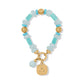 Brighton beaded bracelet with aqua and turquoise stones, gold-tone accents, and engraved Be Kind charm on a white background
