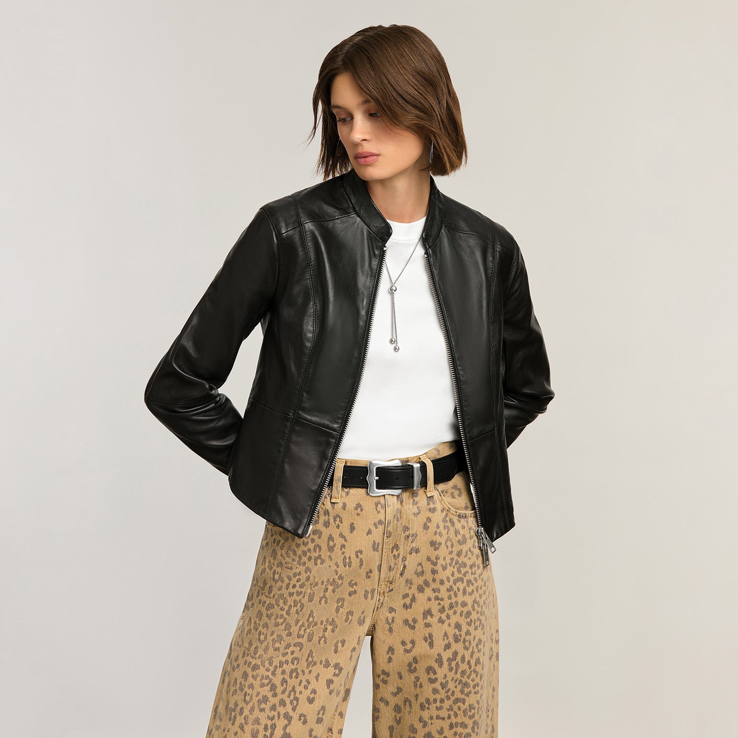 Model wearing a Brighton black leather jacket with zip front and stand collar, styled with coordinating Brighton accessories