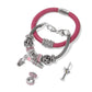 Brighton silver-plated charm bracelets styled with pink leather band, crystal beads, lipstick and martini charms on white background