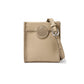 Brighton crossbody handbag in beige pebbled leather with whipstitch trim and circular medallion accent on a white background
