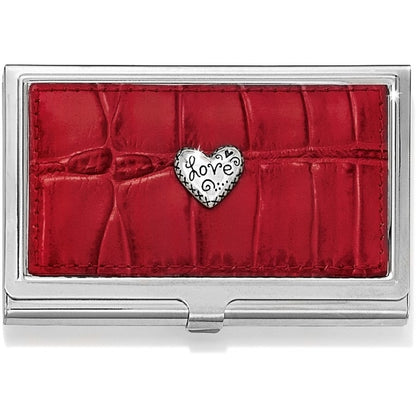Brighton business card case with red croc-embossed leather panel and silver-tone heart love medallion on a white background