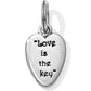 Brighton heart charm with silver-plated finish and engraved Love is the key inscription on a white background
