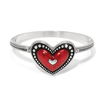 Brighton hinged bangle bracelet with red enamel heart centerpiece and silver-plated beaded trim on a white background