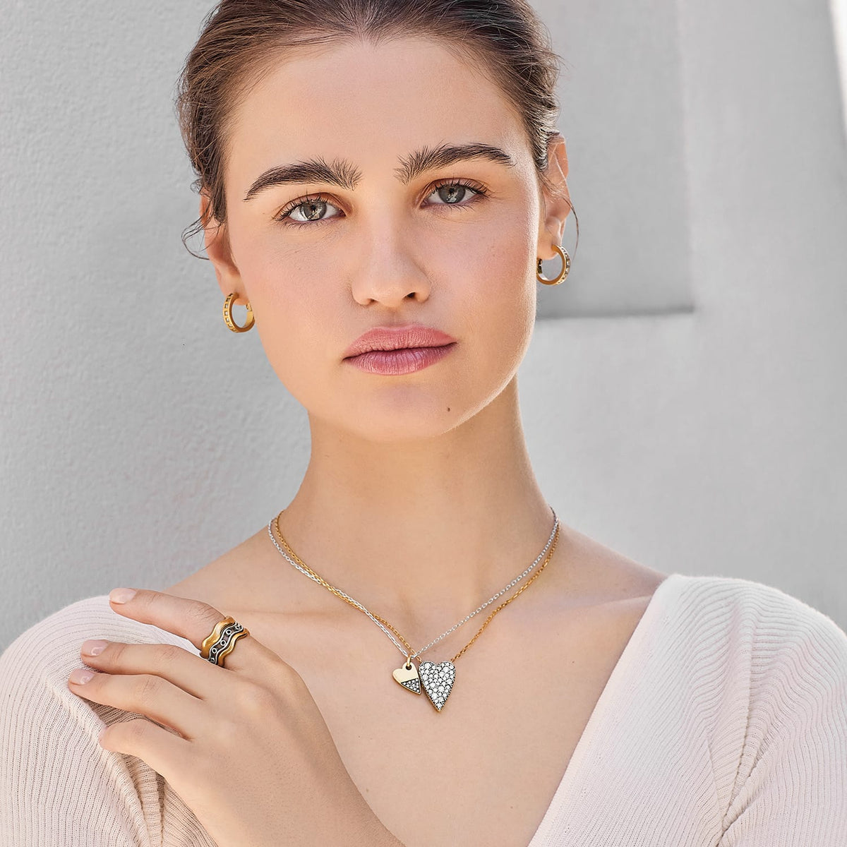 Model wearing a Brighton two-tone layered heart pendant necklace with crystals and coordinating Brighton accessories