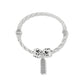 Brighton silver-plated twisted bangle bracelet with beaded charms and engraved rectangular pendant on a white background