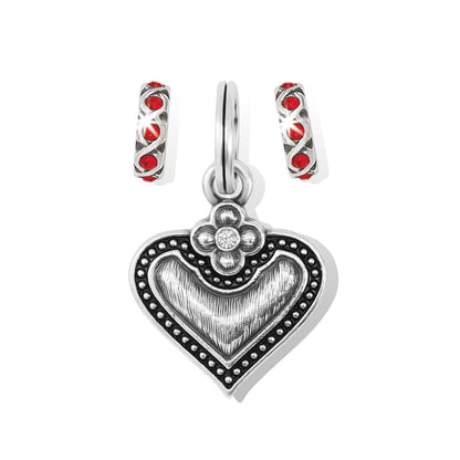 Brighton heart charm with silver-plated beaded border, flower accent, and two red crystal spacer charms on a white background
