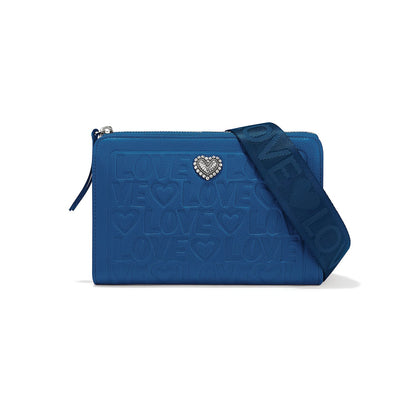 Brighton blue leather crossbody handbag with embossed Love print, silver heart accent, and woven strap on a white background