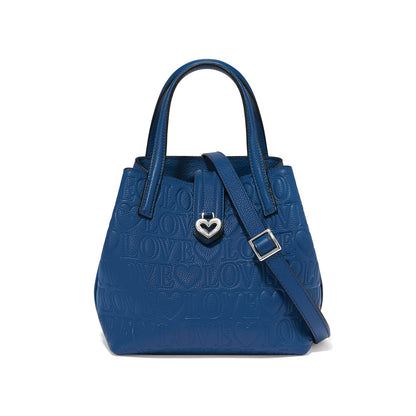 Brighton handbag in blue embossed leather with repeating Love motif, silver-tone heart charm, and adjustable strap on a white background